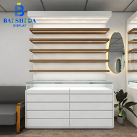 Vitrine murale moderne en bois blanc sur mesure avec éclairage LED et comptoir en verre verrouillable pour magasin d'optique, présentoir à lunettes