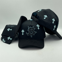 Casquette de baseball noire style trucker avec logo B à motif épine gothique, ornée de croix en strass bleu clair sur toute la surface et de patchs latéraux