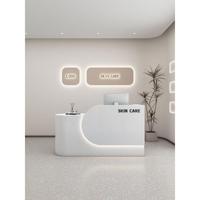 Comptoir de réception simple en MDF rectangulaire arrondi pour magasin de vêtements, salon de beauté, studio de yoga, design style crème, finition cuite