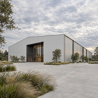 Bâtiment commercial moderne en structure acier préfabriquée, avec bardage isolant, pour entrepôt, bureau ou atelier.