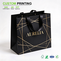 Sac en papier noir imprimé sur mesure avec motif ligné doré et poignée en ruban de satin pour emballage de luxe pour boutiques et vente en gros