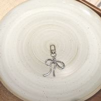 Porte-clés délicat nœud et cœur - Breloque de sac minimaliste en argent pour usage quotidien et décoration de sac