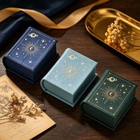 Nouvelle boîte à bijoux vintage en forme de mini livre, en cuir PU éponge, imprimée quatre couleurs, estampée à chaud, pour rangement de bagues, pendentifs et montres motif ciel étoilé