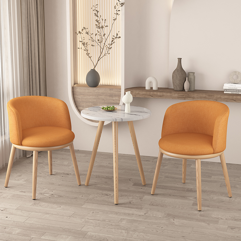 Sedia in tessuto con gambe in legno chiaro, una sedia arancione