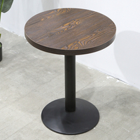 Table carrée en bois avec piétement pyramidal en métal noir et chaises rondes avec coussin vert foncé pour café moderne