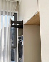 Armoire de buanderie sur mesure pour balcon avec lave-linge et sèche-linge intégrés, étagères dissimulées et tiroirs à fermeture douce