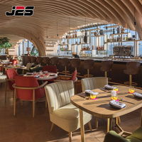 Ensemble de mobilier de restaurant commercial J2S avec banquette en cuir marron, table ronde et chaises en rotin pour projets hôteliers