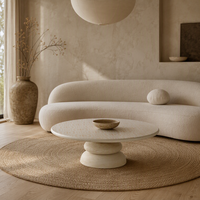 Table basse de luxe en travertin blanc, plateau rond en marbre naturel avec motif gravé, sur piétement colonne en galets empilés