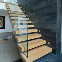 Escalier flottant minimaliste avec marches en bois et balustrade en panneaux de verre transparent