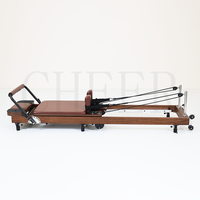 Lit de Pilates pliable professionnel haut de gamme en bois de chêne rouge massif avec finition noyer pour centre de fitness et équipement d'entraînement
