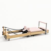 Machine de Pilates Reformer en bois avec coussin rose pour entraînement du tronc, étirements et entraînement complet du corps à domicile ou en studio