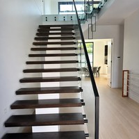 Escalier flottant moderne avec marches en chêne massif, garde-corps en verre, main courante noire, design personnalisé pour villa de luxe, penthouse, hall d'hôtel