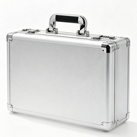 Valise en aluminium argenté avec deux serrures à combinaison, coins renforcés et EVA découpé sur mesure sur le couvercle et la base, valise rigide