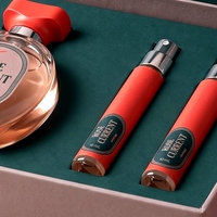 Boîte à parfum rigide de luxe personnalisée de style livre rose magnétique avec doublure en éponge réutilisable et deux flacons vaporisateurs de voyage