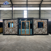 Maison conteneur extensible avec revêtement en pierre, bardage imitation pierre, cadre noir, finition grain de bois, porte double vitrage, entrepôt préfabriqué moderne
