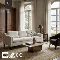 Canapé en tissu trois places haut de gamme et élégant avec coussins de dossier moelleux et pieds en bois de noyer pour projet d'aménagement intérieur de salon de villa