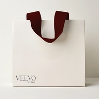 Sacs en papier blancs élégants en gros avec poignées en ruban de satin noir, logo personnalisé imprimé
