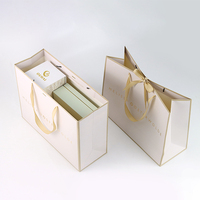 Maßgefertigte Papiertüten in Champagner-Gold, Elegante Verpackungstaschen mit Geprägtem Firmenlogo für Luxuriöse Einzelhandels- und Geschenkanlässe