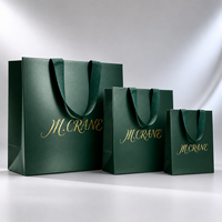Sac cadeau en papier vert émeraude de luxe personnalisé avec logo doré et poignées en ruban gros-grain