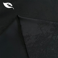 Tissu jacquard satiné effet acétate, motif branche fine noir ton sur ton, brillance soyeuse, tombé lourd, pour Abaya de luxe