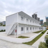 Maison modulaire à deux étages en conteneurs, cabane préfabriquée à ossature acier avec balcon et couloir pour hébergement, bureau ou location.