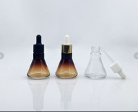 Bouteille d'huile de sérum de sortie d'usine bouteille d'huile essentielle en verre conique avec pompe à bouton-poussoir forme de cylindre emballage Premium