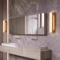 Applique murale JYLIGHTING en forme de capsule, en albâtre naturel rétroéclairé, avec plaque en bronze bruni, pour suite grand luxe de l'hôtel Regent