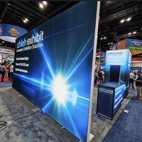 Stand d'exposition IAAPA personnalisé 30x30 avec éclairage, design modulaire, mur rétroéclairé en tissu SEG, comptoir d'accueil avec espace de rangement