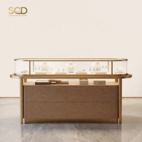 Comptoir de bijouterie ovale de luxe avec vitrine large en verre trempé, cadre doré, étagère ouverte, kiosque de vente au détail, aménagement de magasin personnalisé, éclairage LED