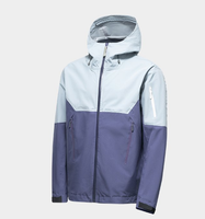 Veste à capuche bicolore bleu glace et violet, poche zippée sur le bras, poches latérales zippées, coupe-vent technique color block