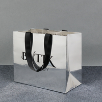 Sac en papier laminé holographique argenté de luxe, personnalisé avec logo noir imprimé à chaud
