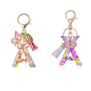 Popular venta directa de fábrica llavero de resina rosa púrpura 26 letras brillo pequeño colgante mariposa borla en forma de corazón para pequeño - Product Image 1