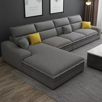 Canapé d'angle modulable beige en forme de L avec chaise longue, coussins à bordure côtelée en tissu et oreillers, idéal pour le salon
