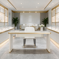 Bureau VIP de luxe blanc cannelé avec finition dorée, pieds colonne, écran LED, niche murale, canapé incurvé, mobilier de boutique de bijoux en marbre