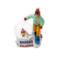 Globo de nieve personalizado con diseño de montaña nevada y esqueros en botas de snowboard, hecho de resina y vidrio.