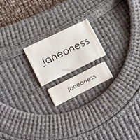 Étiquettes de vêtements en polyester mat imprimées sur mesure avec logo noir et bande en tissu beige pour vêtements de marque, étiquettes à coudre