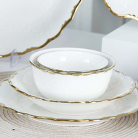 Ensemble d'assiettes et de bols en porcelaine élégants à bords dorés, design festonné, vaisselle en céramique pour repas raffinés