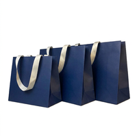 Sac shopping en papier bleu marine personnalisé, couleur unie, carton épais mat, avec poignée en ruban, vente en gros pour les magasins de détail et les marques.