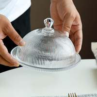 Huisgemaakte afternoon tea cake cloche schaal met verticale gegroefde gestreepte koepelvormige deksel van soda-lime glas voor fruitpresentatie, milieuvriendelijk.