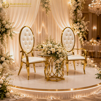 Chaise de mariage de luxe élégante en acier inoxydable doré avec dossier ovale capitonné en cristal et accoudoirs, idéale pour la location événementielle