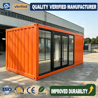 Conteneur en acier ondulé orange avec murs entièrement vitrés, portes doubles et mobilier adapté pour bureau ou espace de vie