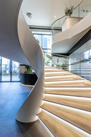 Escalier courbé empilable moderne avec garde-corps en verre et balustrade métallique, écologique, pour usage intérieur, durable, idéal pour hôtels et villas
