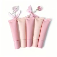 Emballage unique de gloss à lèvres rose en tube souple avec applicateur en cristal