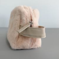 Pochette de maquillage en fausse fourrure de lapin rose pâle et moelleuse, avec poignée latérale en PU crème et fermeture éclair, idéale pour les voyages d'hiver, les soins de beauté et comme cadeau de fêtes.