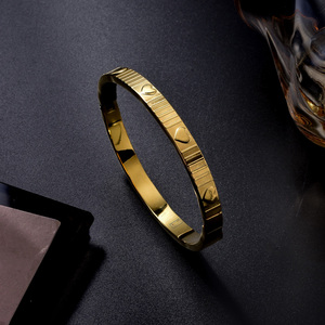 Pulseras y brazaletes finos de oro de 18k, circulares, refinados, pulidos, resistentes al óxido, con decoración de corazón moderna y distintiva de grano rayado, atemporales. - Product Image 1