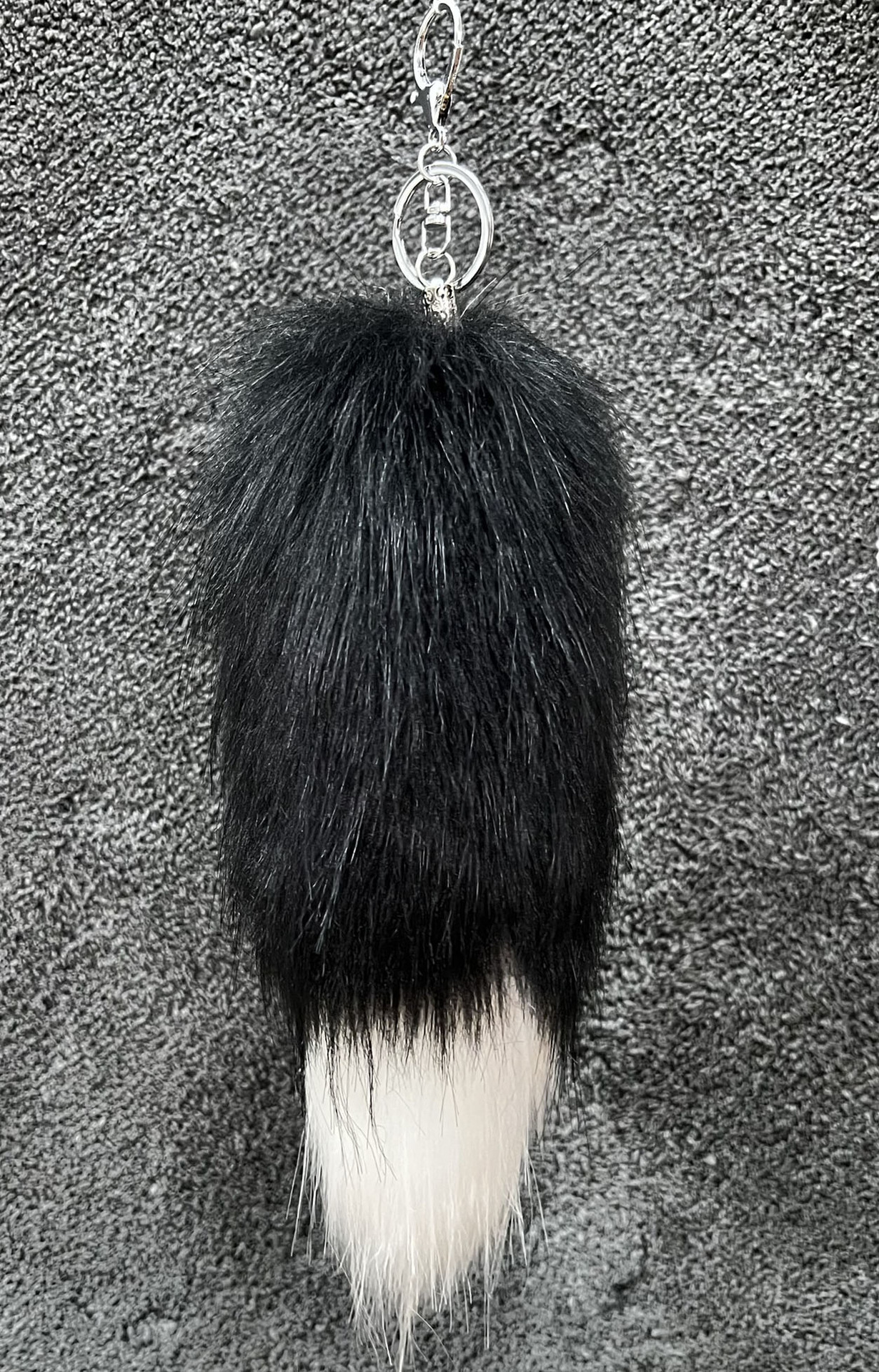Corps noir avec pointe blanche, longueur des poils 25 cm