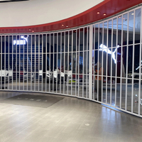 Porte pliante moderne en alliage d'aluminium avec cadre incurvé en cristal, cloison transparente sur mesure pour les intérieurs de centres commerciaux et de magasins