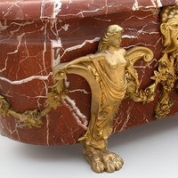Baignoire autoportante ovale en marbre rouge avec veines blanches, pieds sculptés en forme de sirène et tête de lion dorée, luxe pour hôtel