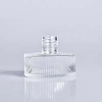 Flacon diffuseur d'aromathérapie en verre rond plat à grain vertical de luxe 100 ml avec bouchon à vis et logo personnalisé