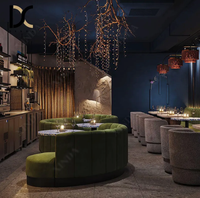 Canapé banquette capitonné en velours vert à cannelures courbes, table ronde à plateau en terrazzo bleu pour restaurant, bar à vin ou lounge aux tons sombres